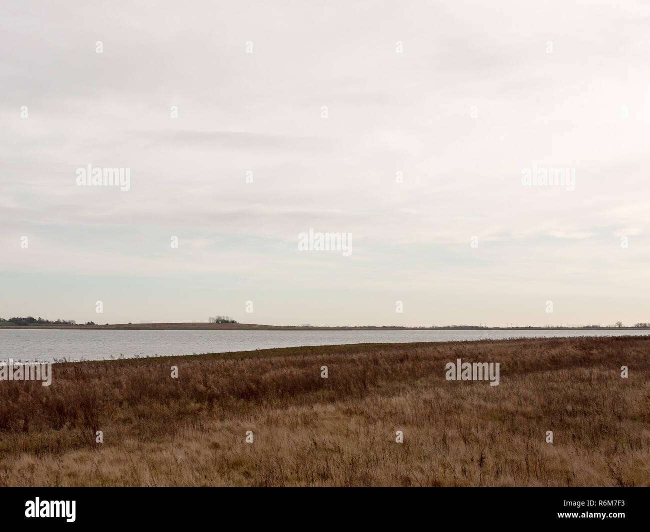 Offene Meer Küste Ebene mit Gras vor Horizont bedeckt klare Ruhe Stockfoto