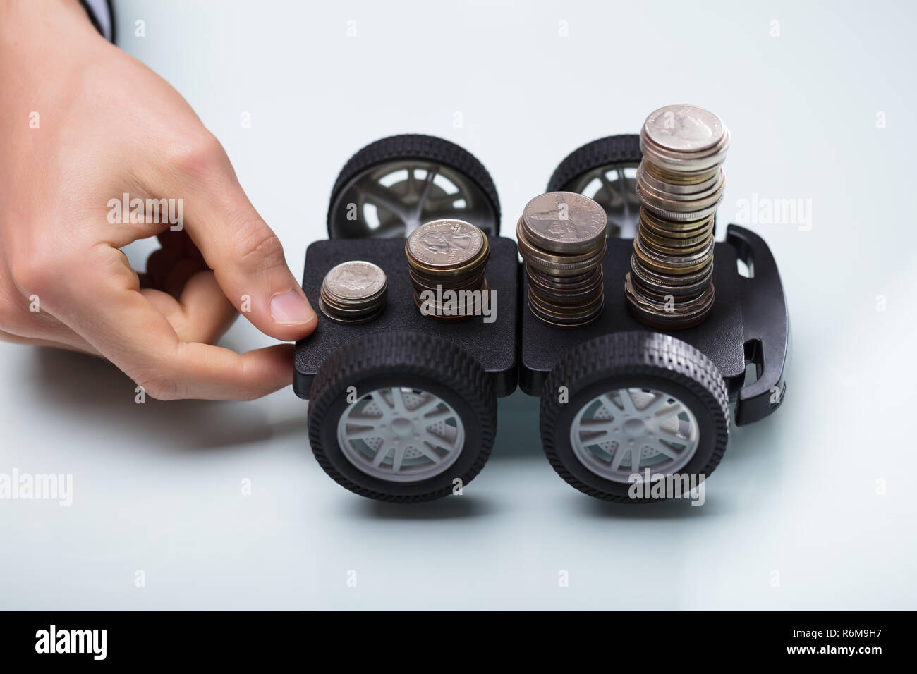 Hand, schwarz Warenkorb mit Stapel von Münzen Stockfoto