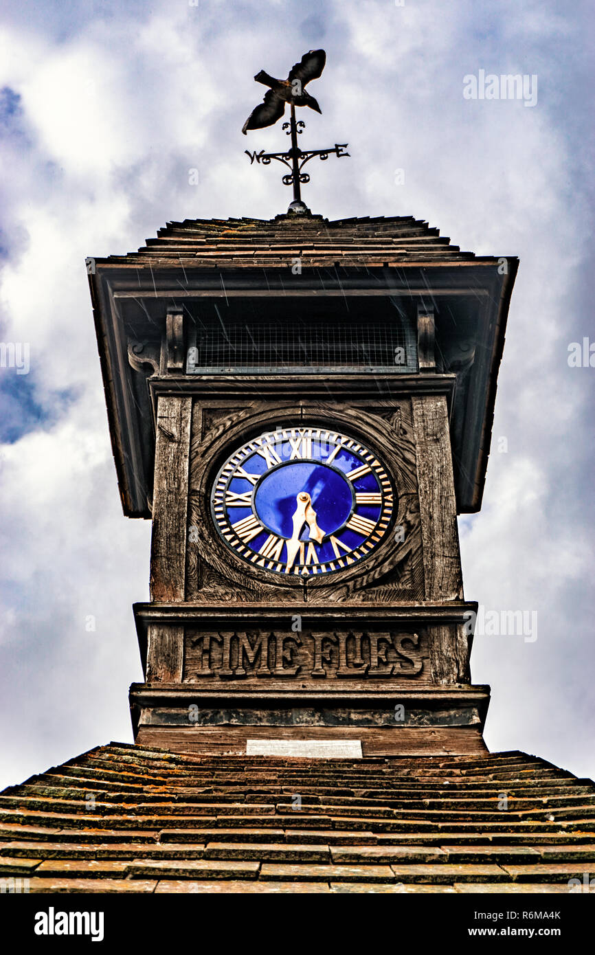 Die Zeit fliegt, sehr alte Uhr, draußen an einem regnerischen Tag Stockfoto