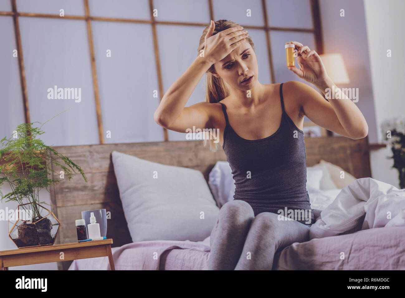 Hübsche Frau mit Kopfschmerzen Kontrolle Anzahl der Painkiller Pillen Stockfoto