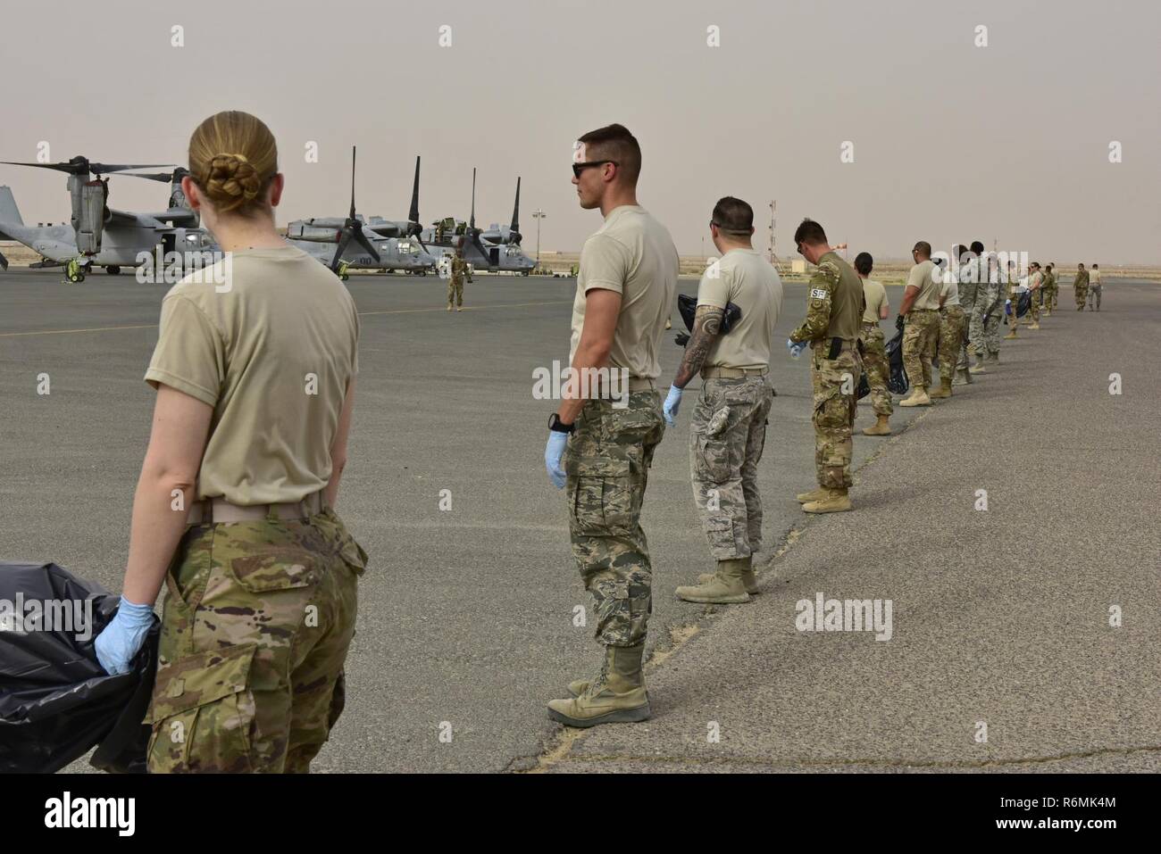 Us Air Force Mitglieder der 407 Air Expeditionary Gruppe bereiten ein Foreign Object Damage (FOD) Spaziergang auf dem Flugplatz, 24. Mai 2017 durchführen zu können. Die FOD-Spaziergang wurde von Flight Safety und Flugplatz management abgestimmt, um sicherzustellen, dass der Bereich frei von Ablagerungen, die Schäden an Flugzeugen führen und den Flugbetrieb behindert wurde. Stockfoto