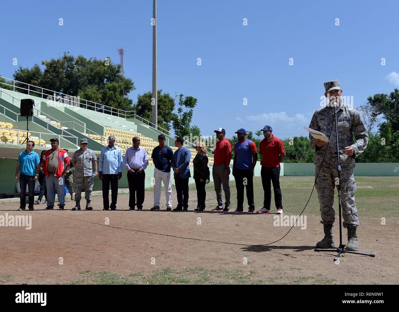 Us-Luftwaffe Kapitän Alejandro Dieguez, die 346 Air Expeditionary Gruppe Judge Advocate, Adressen von Teilnehmern und Eltern als Zeremonienmeister für einen Baseball Clinic die Task Force für Bereich Kinder Mai 20, 2017, in San Juan de la Maguana, Dominikanische Republik gehostet werden. Der baseball Clinic, die von der Task Force in Zusammenarbeit mit verschiedenen Nichtregierungsorganisationen und anderen Organisationen organisiert, bot US-Mitglieder die Möglichkeit, ehemalige Major League Baseball Spieler und Trainer auf ein denkwürdiges Ereignis für 450 Kinder, Eltern und andere Teilnehmer zu unterstützen. Stockfoto