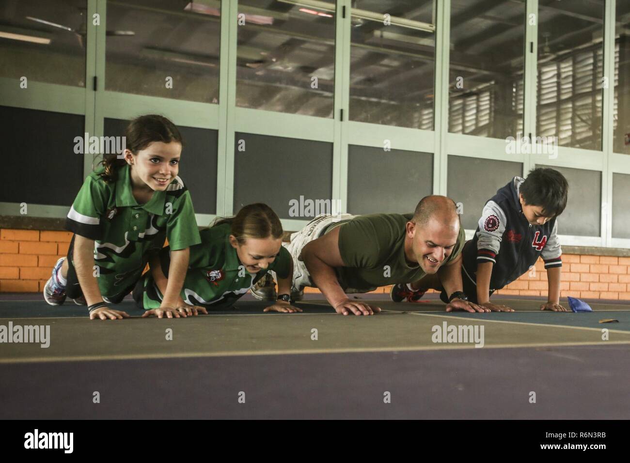 DARWIN, Australien - US Marine Staff Sgt. Bret Daneker, platoon Sergeant, Unternehmen I, 3., 4. Marine Regiment, 1st Marine Division, Marine Drehkraft Darwin, das Marine Corps Push-Ups mit Studenten während eines freiwilligen Fall, 31. Mai 2017. Die gleiche Gruppe von Marines wird weiterhin der Besuch und die Betreuung der Studierenden während ihrer Zeit in Darwin. Die Marines sind in den Dienst der lokalen Gemeinschaft verpflichtet und wird weiterhin eine Auswirkung, wenn verfügbar zu machen. Stockfoto