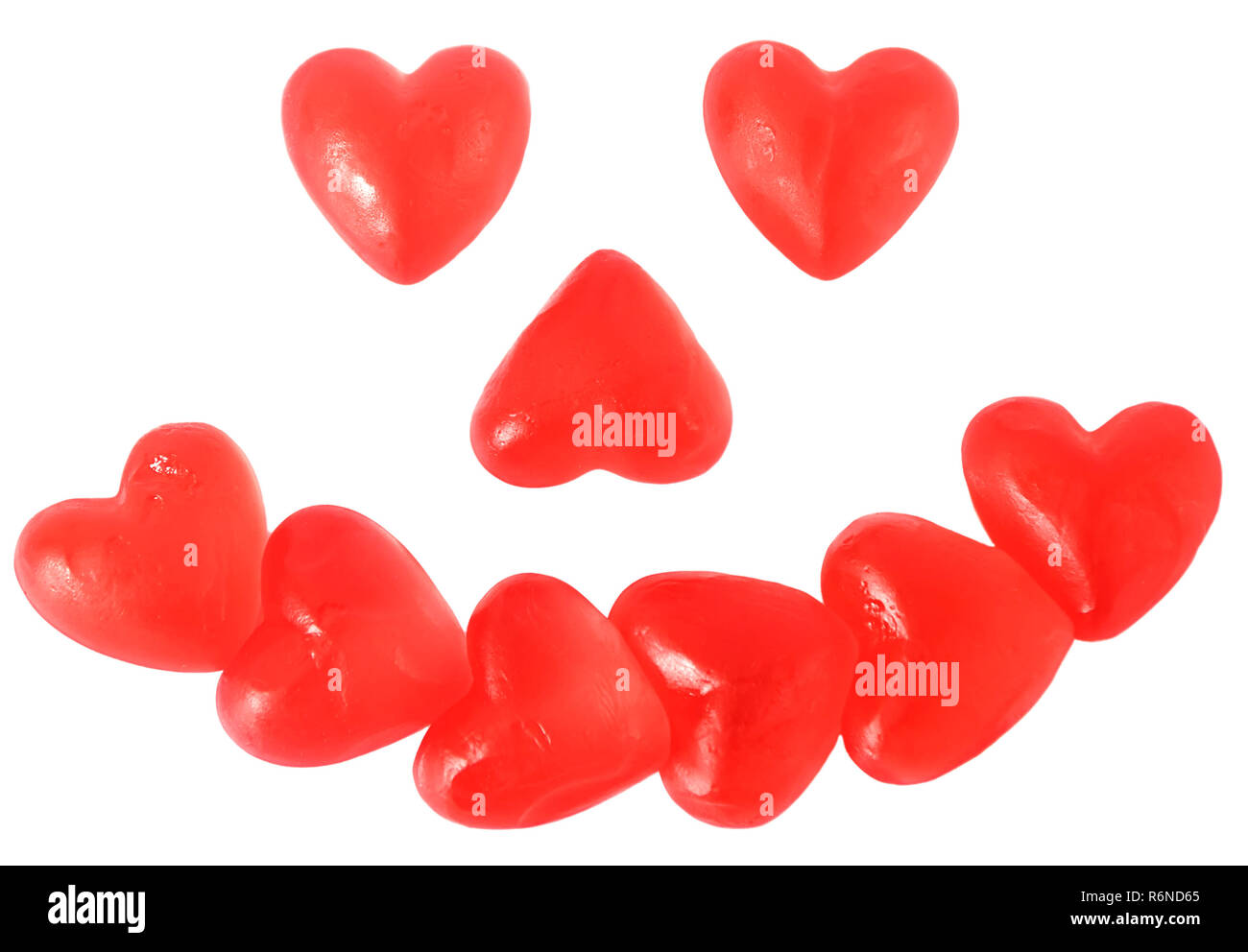 Leuchtend rote Gelee Herz geformten Süßigkeiten in Form eines lächelnden Happy Face auf weißem Hintergrund Stockfoto