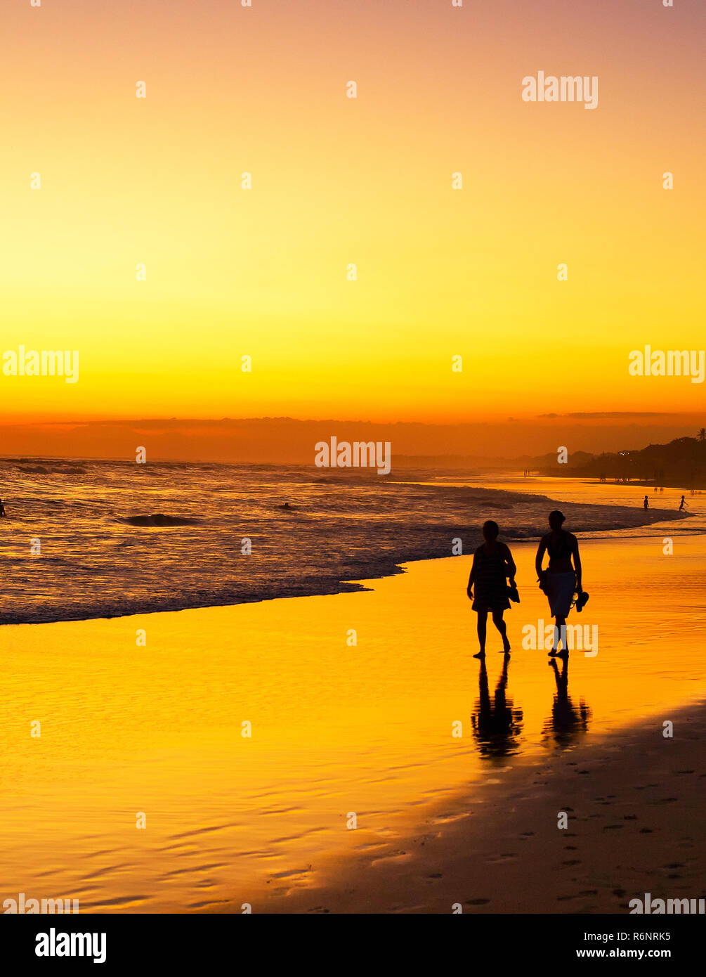 Menschen zu Fuß auf den Strand bei Sonnenuntergang. Silhouette. Die Insel Bali, Indonesien Stockfoto