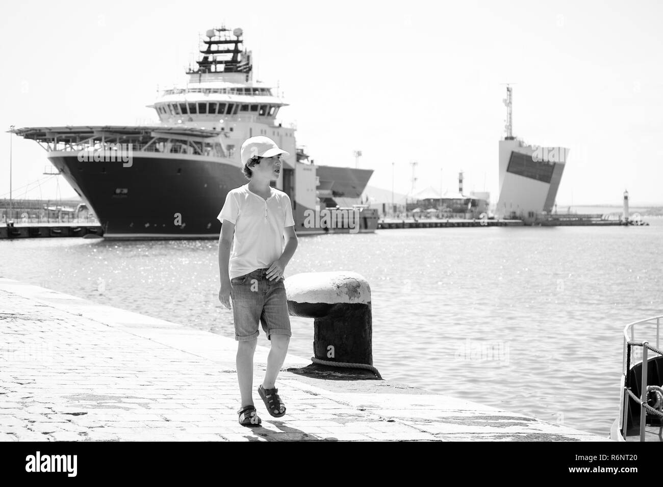 Der junge Spaziergänge entlang der Hafen der Hafen. Schwarz und Weiß. Stockfoto