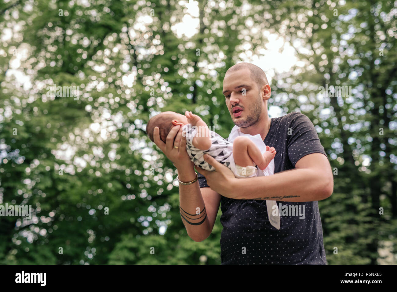 Liebevoller Vater mit seinem Baby boy in seinen Händen außerhalb Stockfoto