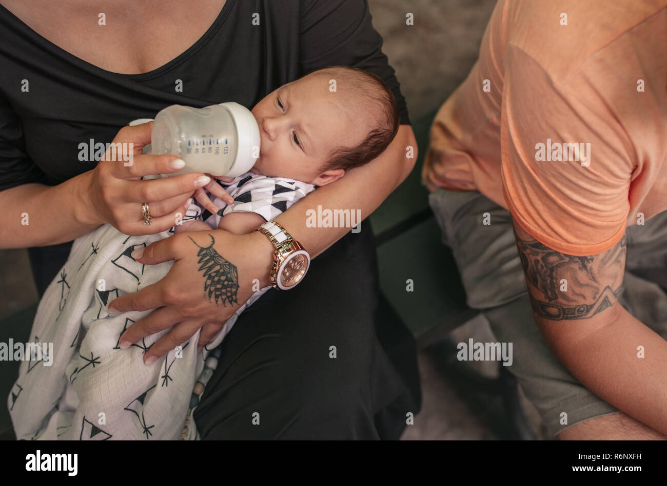 Mutter füttern Ihr süsses Baby Boy während draußen sitzen Stockfoto