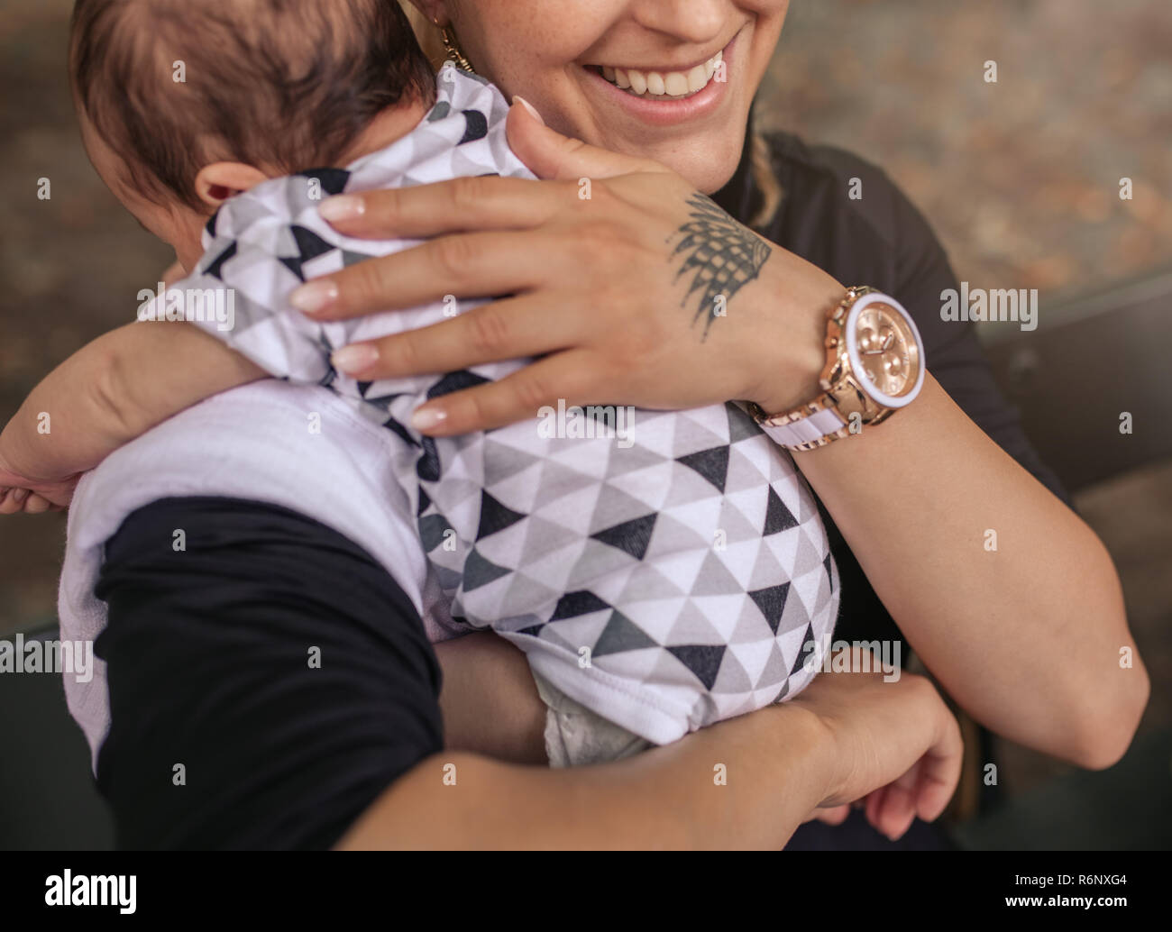 Lächelnde Mutter draußen sitzen mit ihren niedlichen Baby Boy Stockfoto