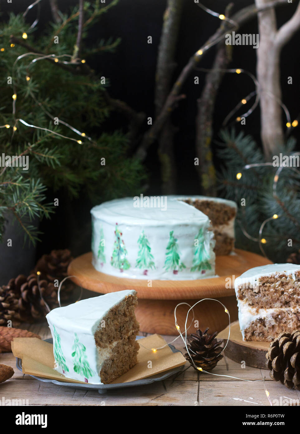 Festliche Kuchen mit gemalten Weihnachtsbaum auf einem dunklen Hintergrund der Zweige und Zapfen dekoriert. Im rustikalen Stil. Stockfoto