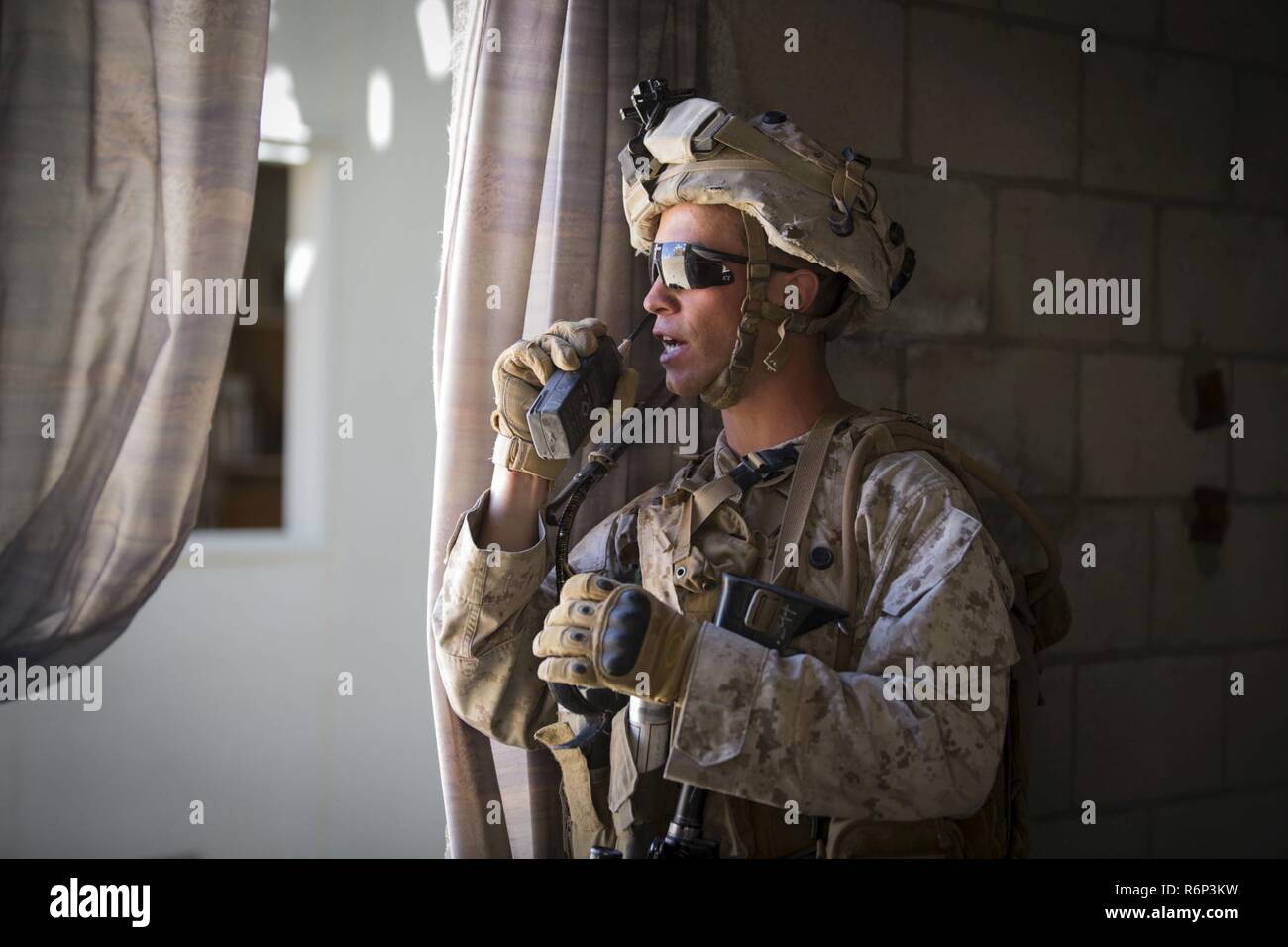 MARINE Corps Air Ground Combat Center Twentynine Palms, Kalifornien - Cpl. Kevin Masellah, ein squadleader mit 3 Platoon, Golf Company, 2nd Battalion, 7th Marine Regiment, kommuniziert mit seinen Mannschaftskameraden von feindlichen Personal im Bereich 200 bei einem städtischen Lane Training an Bord Marine Corps Air Ground Combat Center, Twentynine Palms, Kalifornien, 15. Mai 2017. Die urbanen Kriegsführung Paket, Teil der integrierten Übung 3-17, ist ein platoon - Ebene Bataillon - Größe evolution wo Marines urban patrouillieren geübt, bis zu einem Marine Air Ground Task Force Angriff auf eine gegnerische Stadt gehalten. Es Stockfoto