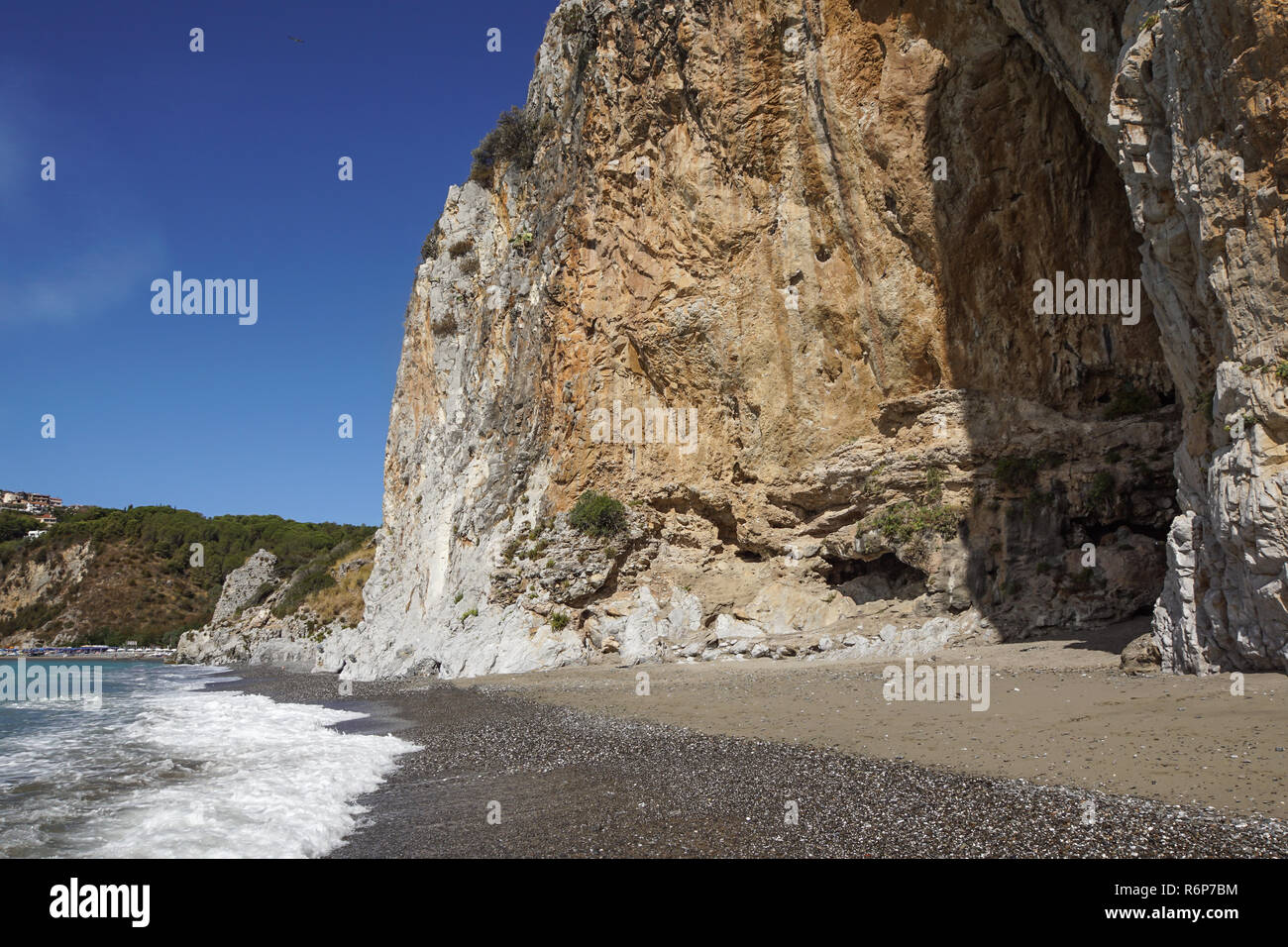 Felsige Wand am Strand in Italien Stockfoto