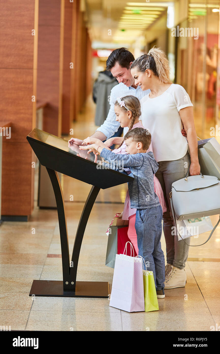 Familie lernt über die Mall auf dem Touchscreen Informationen kiosk Stockfoto