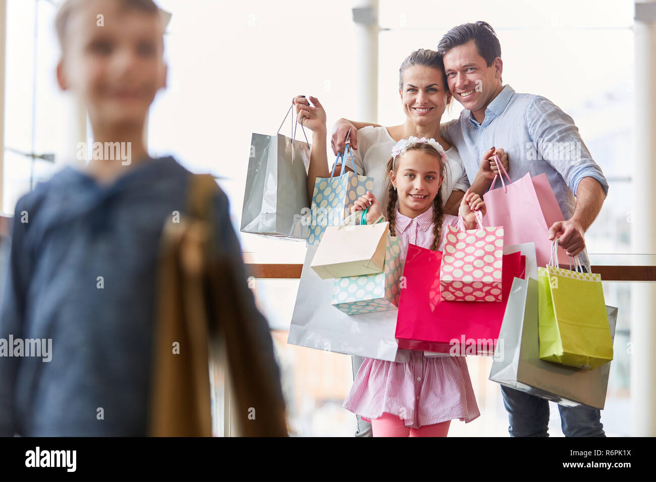 Happy Family zeigt ihre einkaufstaschen als Symbol der Kaufkraft und Konsum Stockfoto