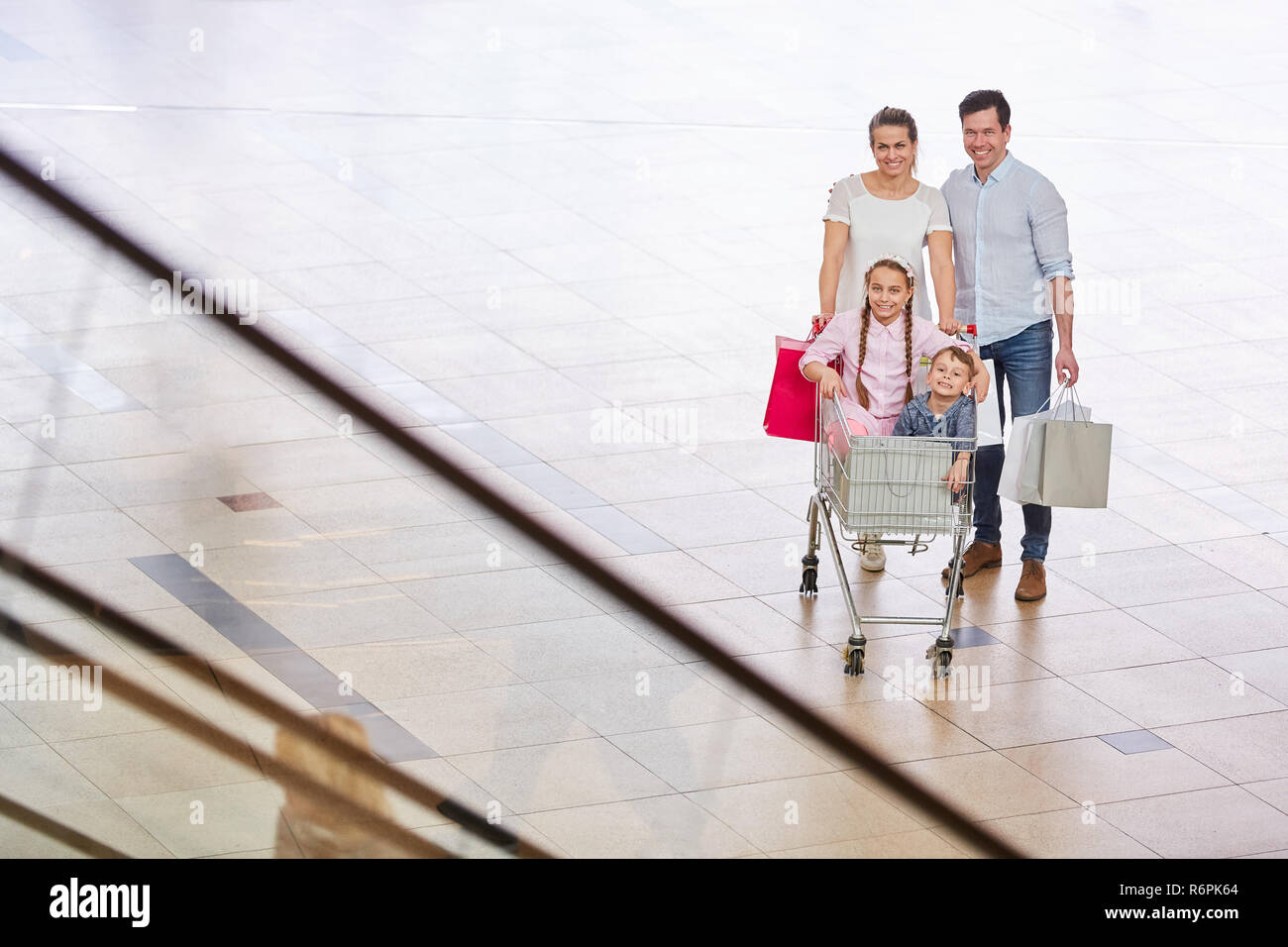 Familie und zwei Kindern im Warenkorb an der Shopping Mall am Wochenende Stockfoto