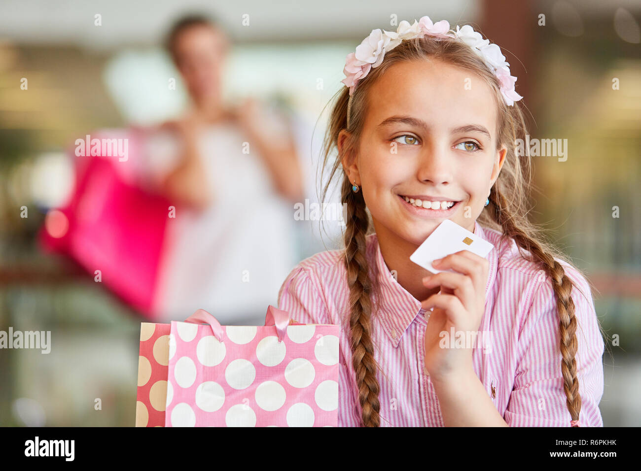 Girl shopping mit einer Treuekarte denkt über Shopping Stockfoto
