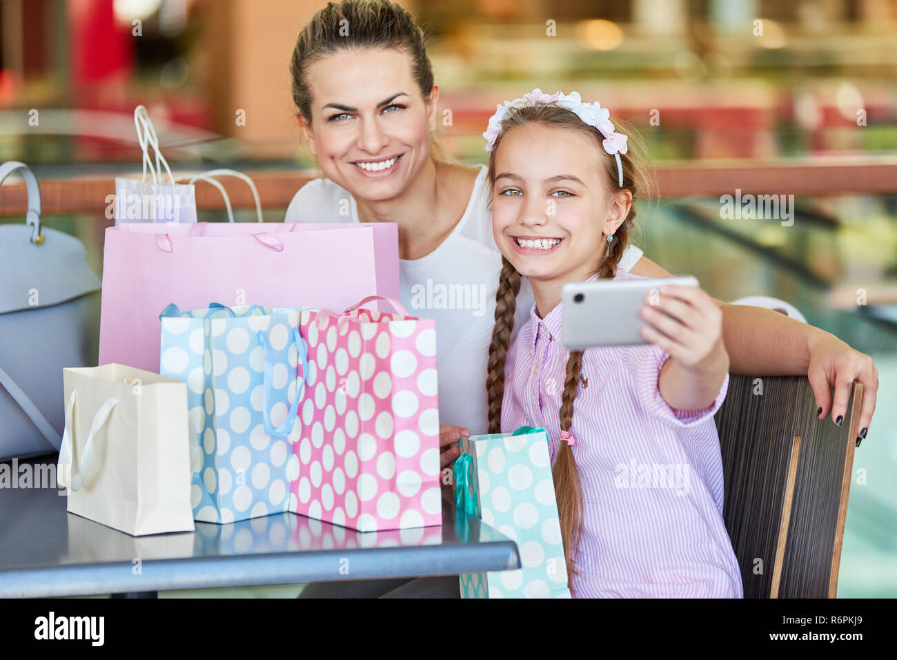 Mädchen nimmt einen selfie von sich selbst und seiner Mutter beim Einkaufen Stockfoto