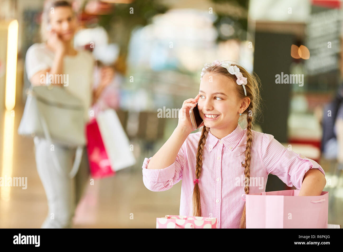 Mädchen Einkaufen im Einkaufszentrum, am Telefon zu sprechen Stockfoto