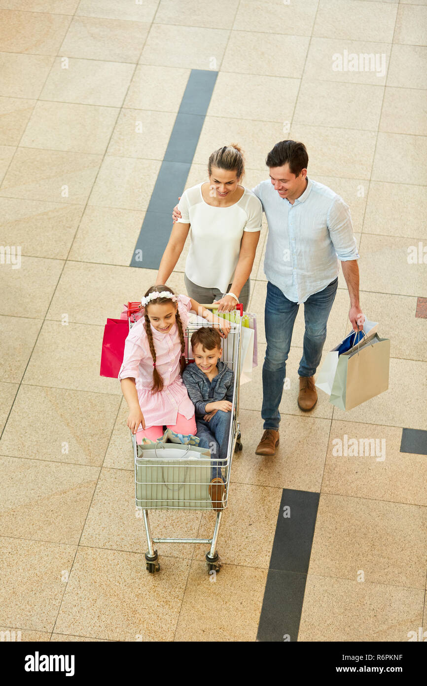 Familie und zwei Kindern mit Warenkorb beim Einkaufen in der Shopping Mall Stockfoto