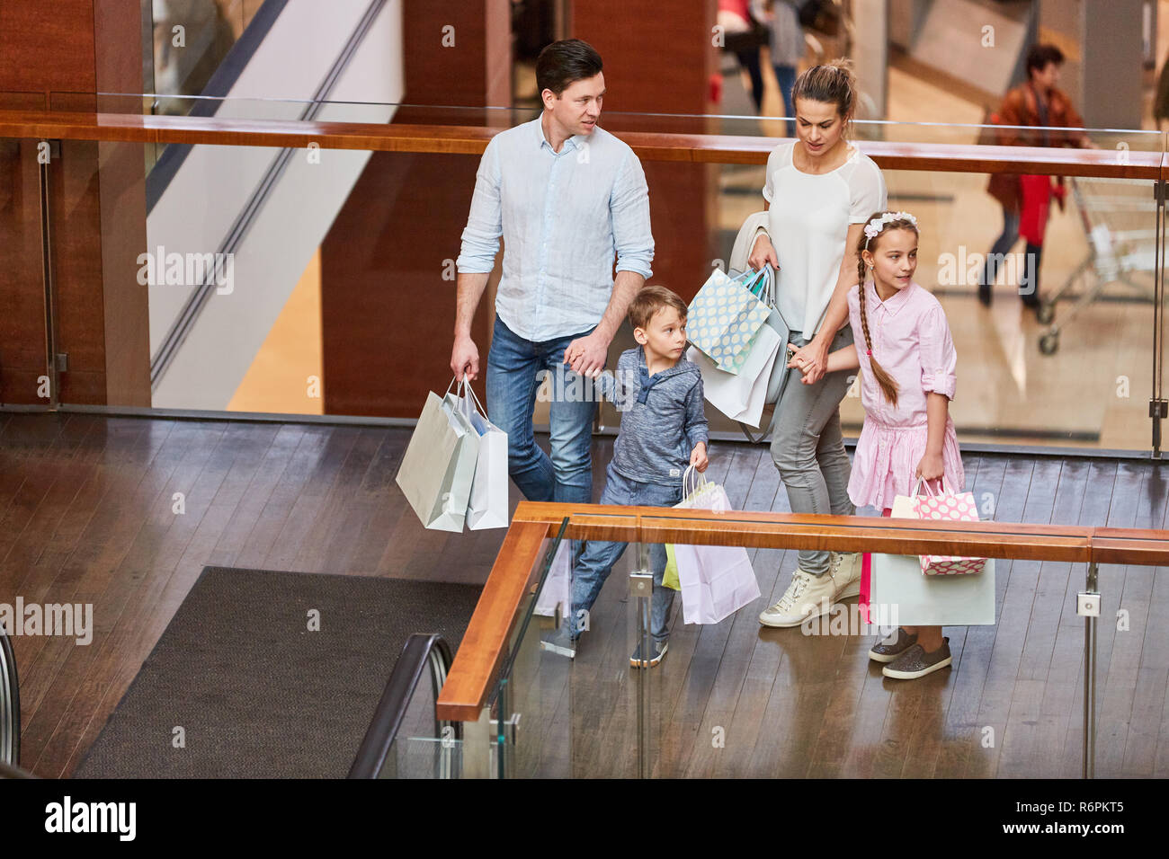 Familie mit zwei Kindern mit Tüten Shopping in der Mall Stockfoto