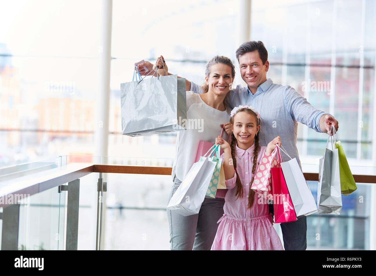 Familie und Kind mit vielen Einkaufstüten als Symbol der Konsum und Kaufkraft. Stockfoto