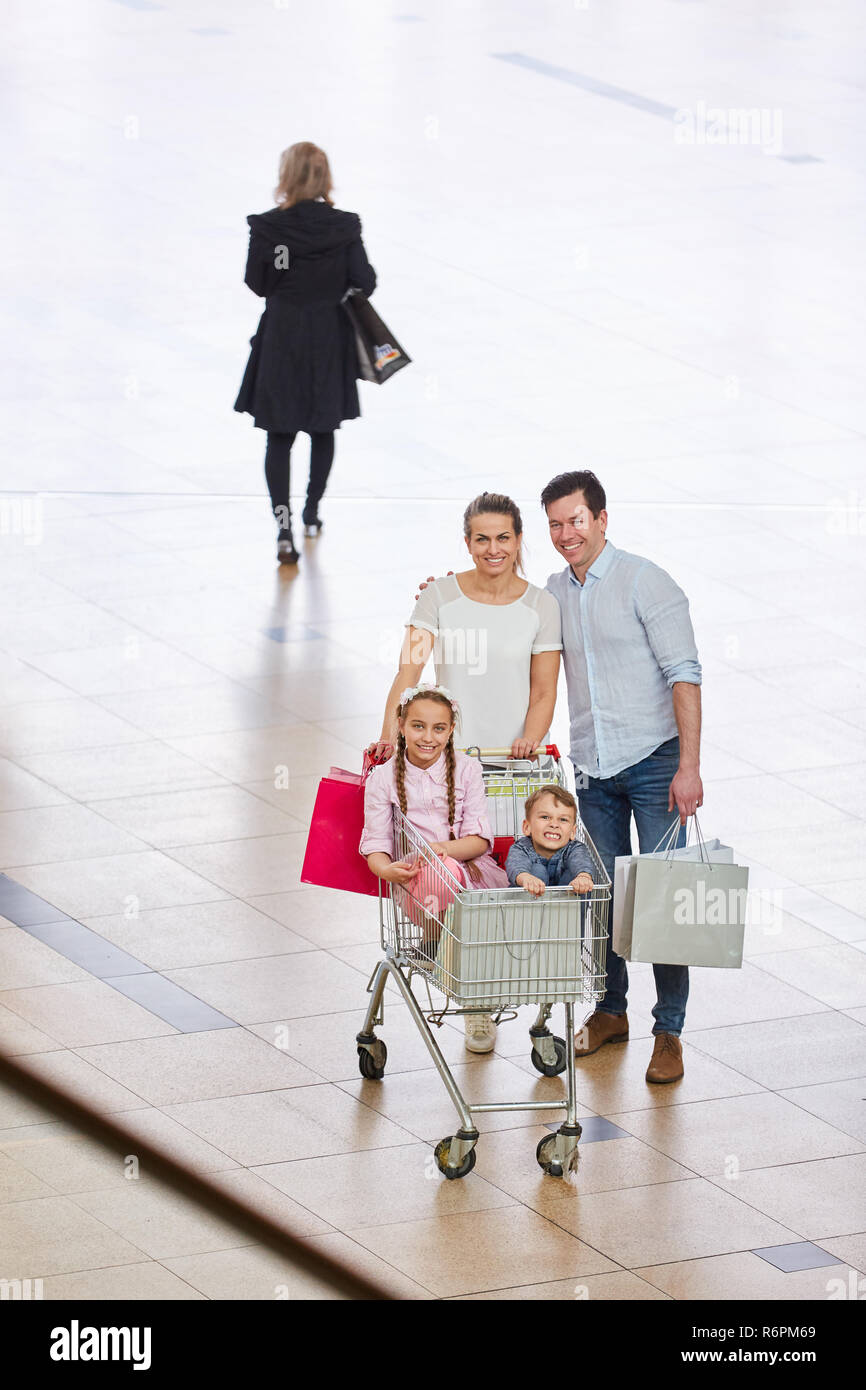 Familie Einkaufen in der Shopping Mall mit zwei Kindern im Warenkorb Stockfoto