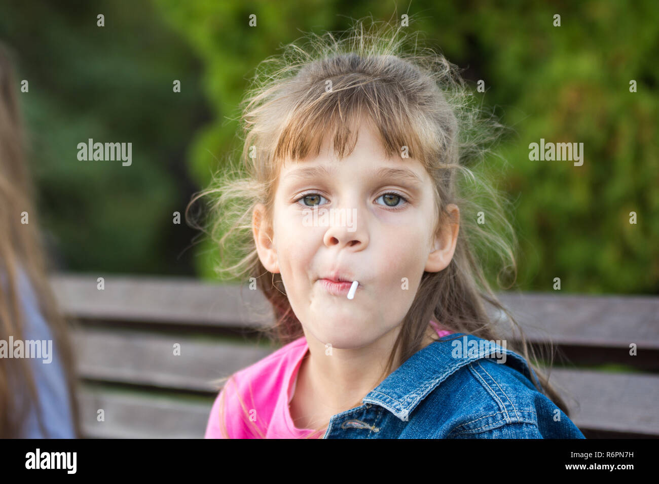 Porträt einer sechs-jährige Schwule Mädchen, saugt einen Lutscher Stockfoto