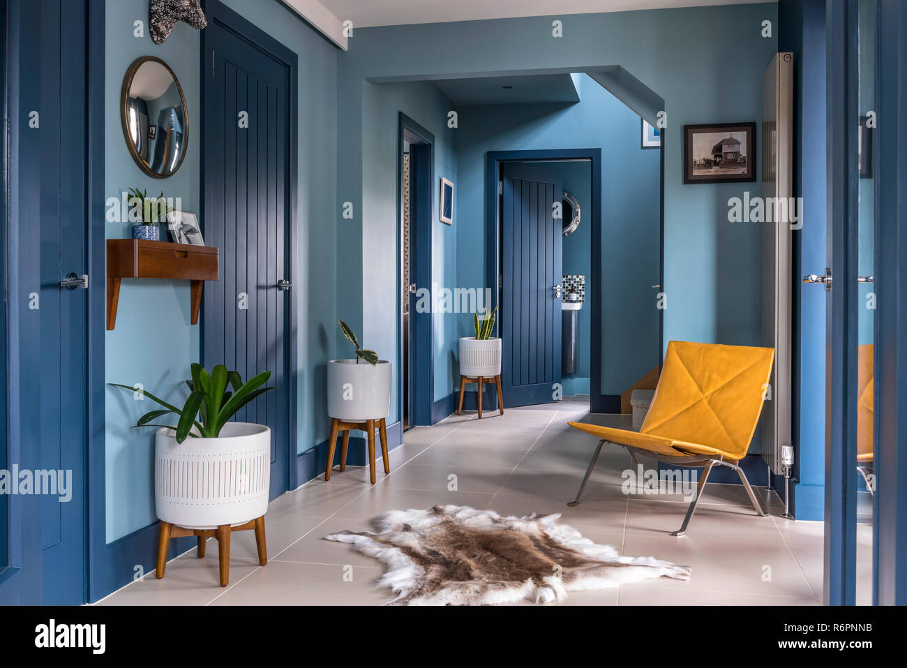 Eingangshalle mit gelben Stuhl und Rentier Wolldecke mit blauen Türen in Hampshire Mill House von Emma Maler neu gestaltet Stockfoto