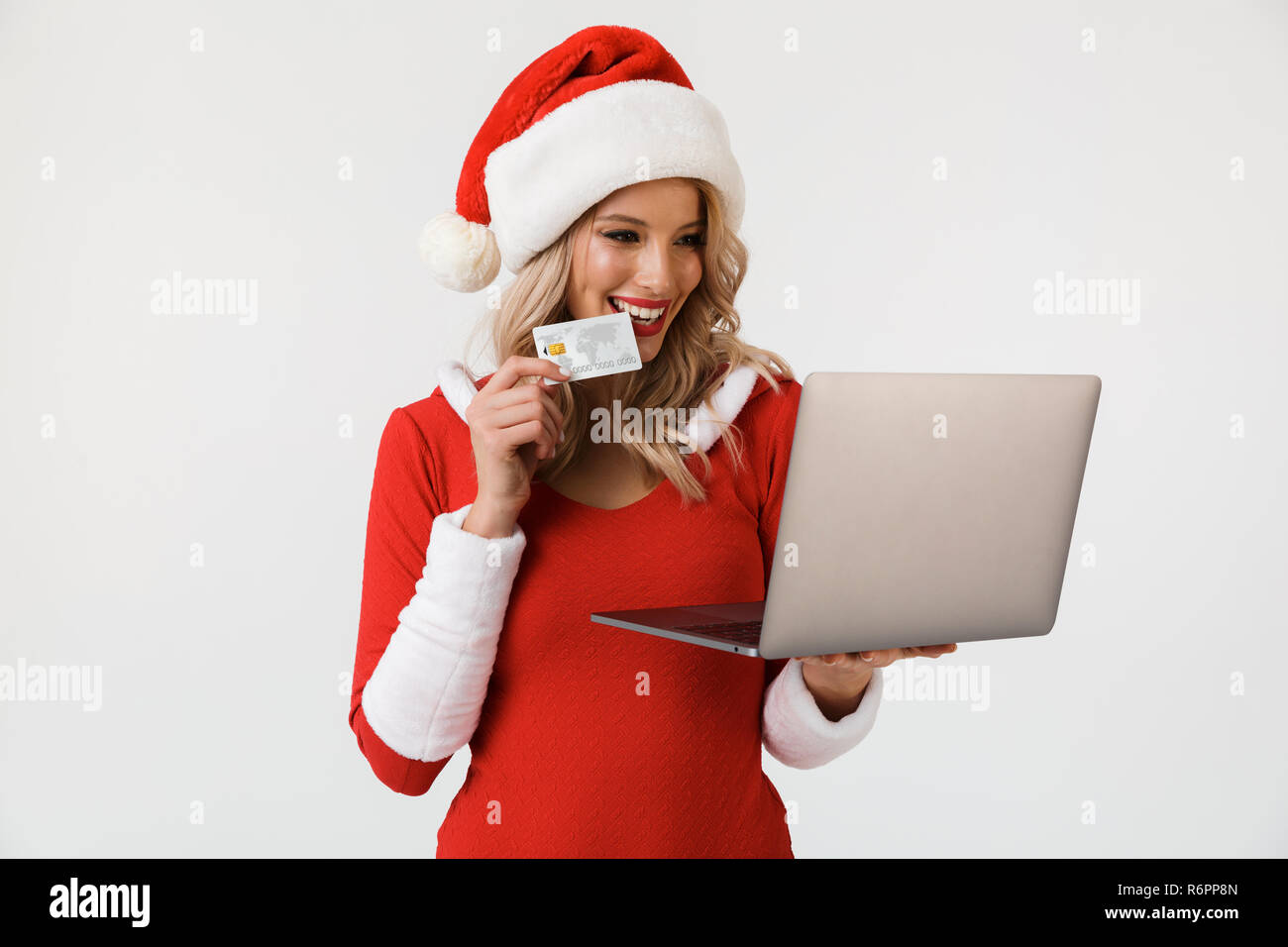 Porträt einer zufrieden blonde Frau in Rot neues Jahr Kostüm auf weißem Hintergrund gekleidet, mit Laptop Computer, Credit ca Stockfoto