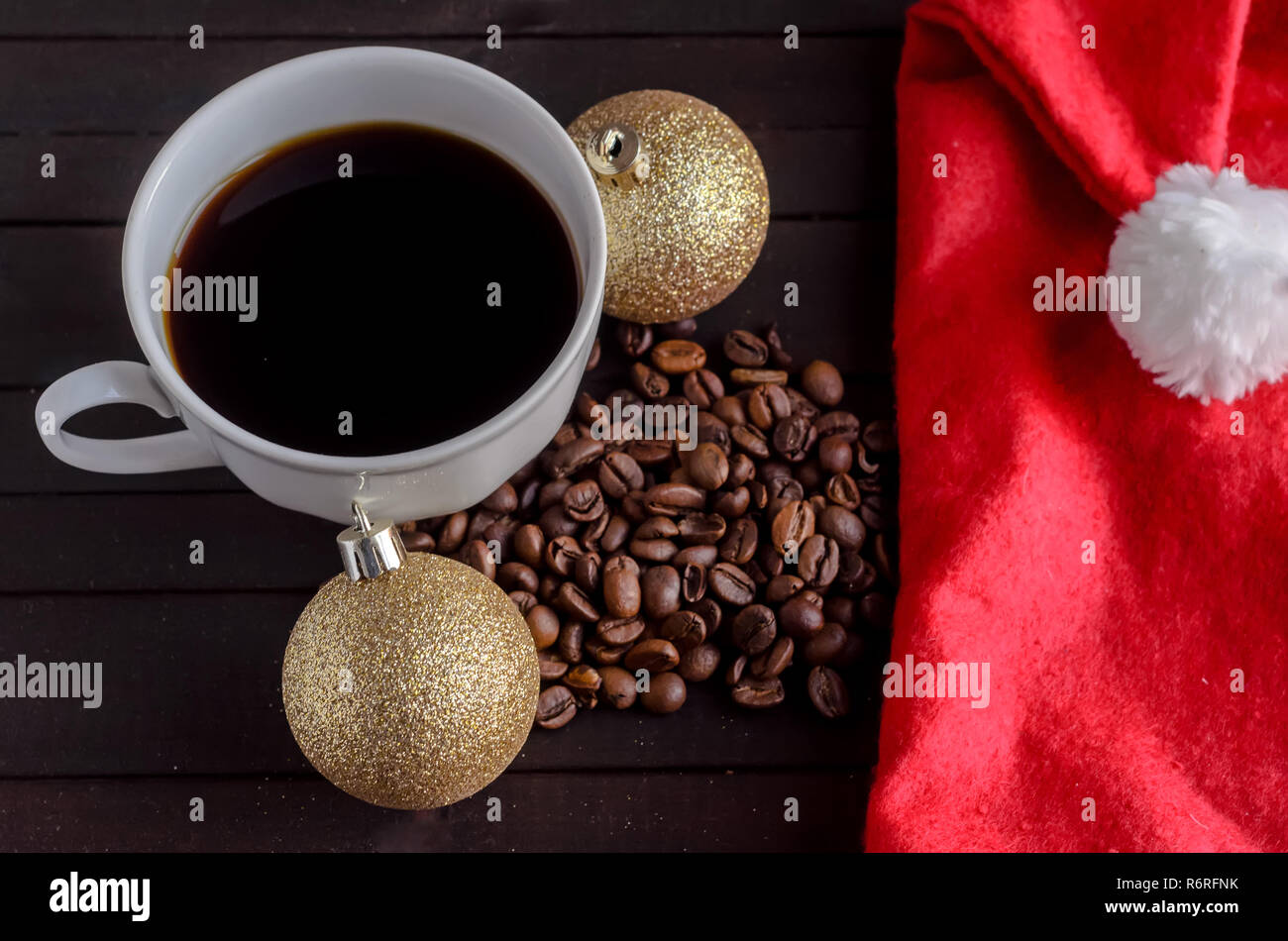 Eine Tasse Kaffee, Kaffeebohnen, zwei Weihnachten Kugeln und Santa hat.  Weihnachten Konzept Stockfotografie - Alamy