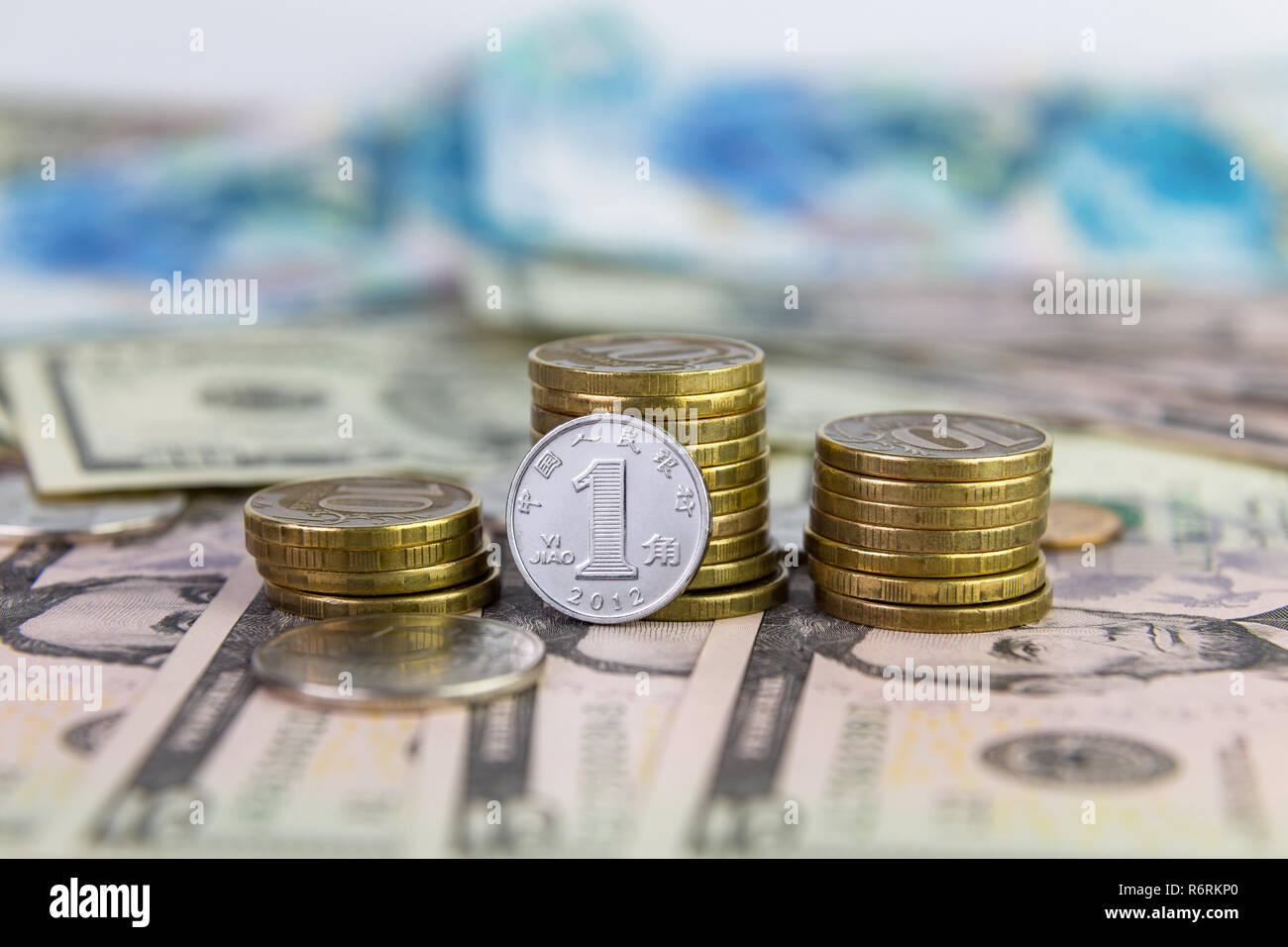 Eine yuan vor dem Hintergrund der gestapelte Münzen 10 Rubel liegen auf dollarscheine Stockfoto