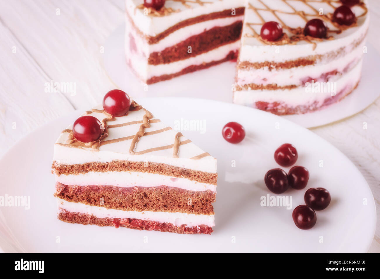 Schokoladenkuchen mit Mousse, dekoriert mit Kirschen Stockfoto