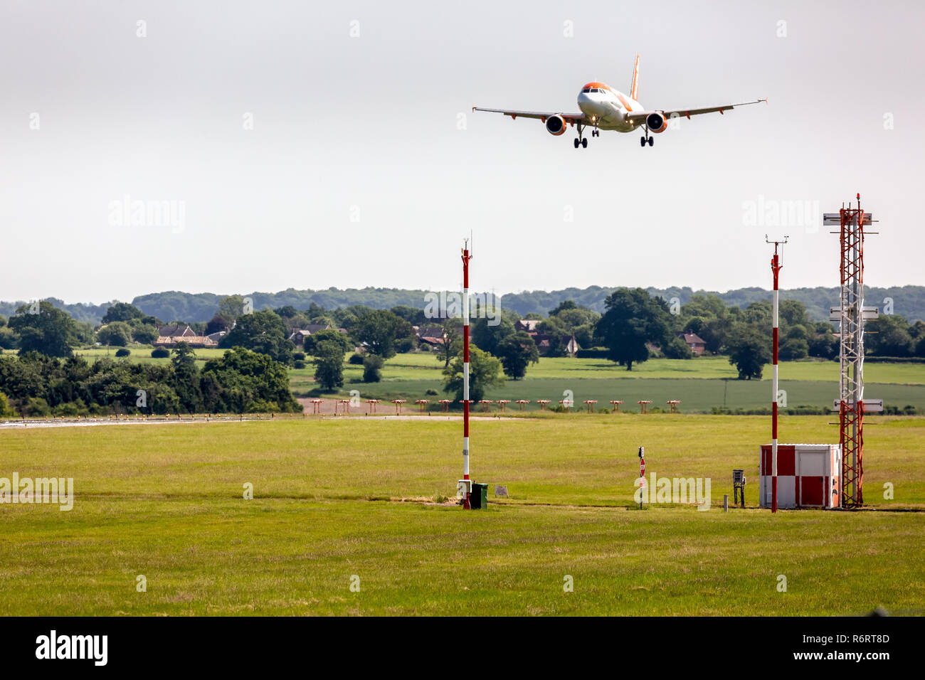 Ein Jet Airliner nähert sich der Landung am Flughafen London Luton in England. Flughafen landen und Navigationsgeräten im Vordergrund sichtbar. Stockfoto