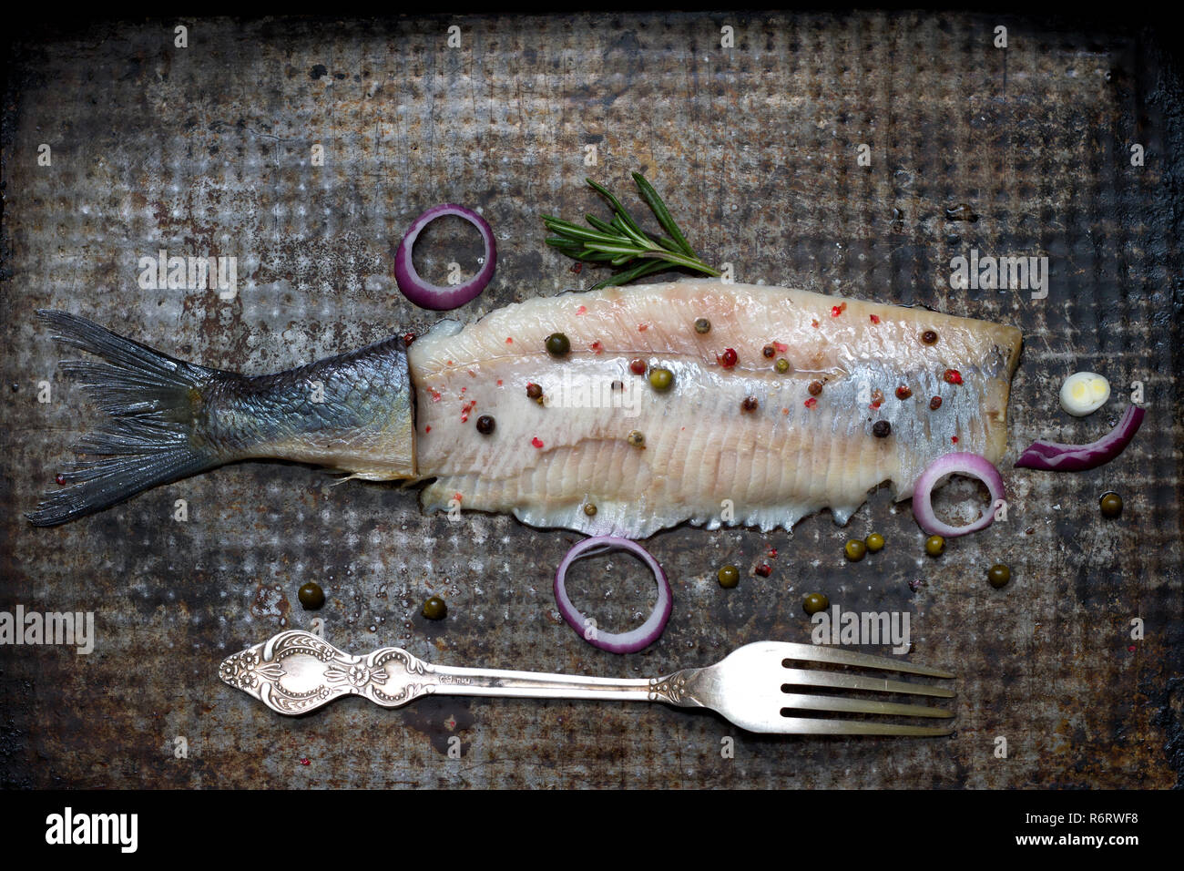 Abstrakte Heringe Fisch mit Gewürzen auf alten grunge Metallplatte kreative noch Leben Stockfoto