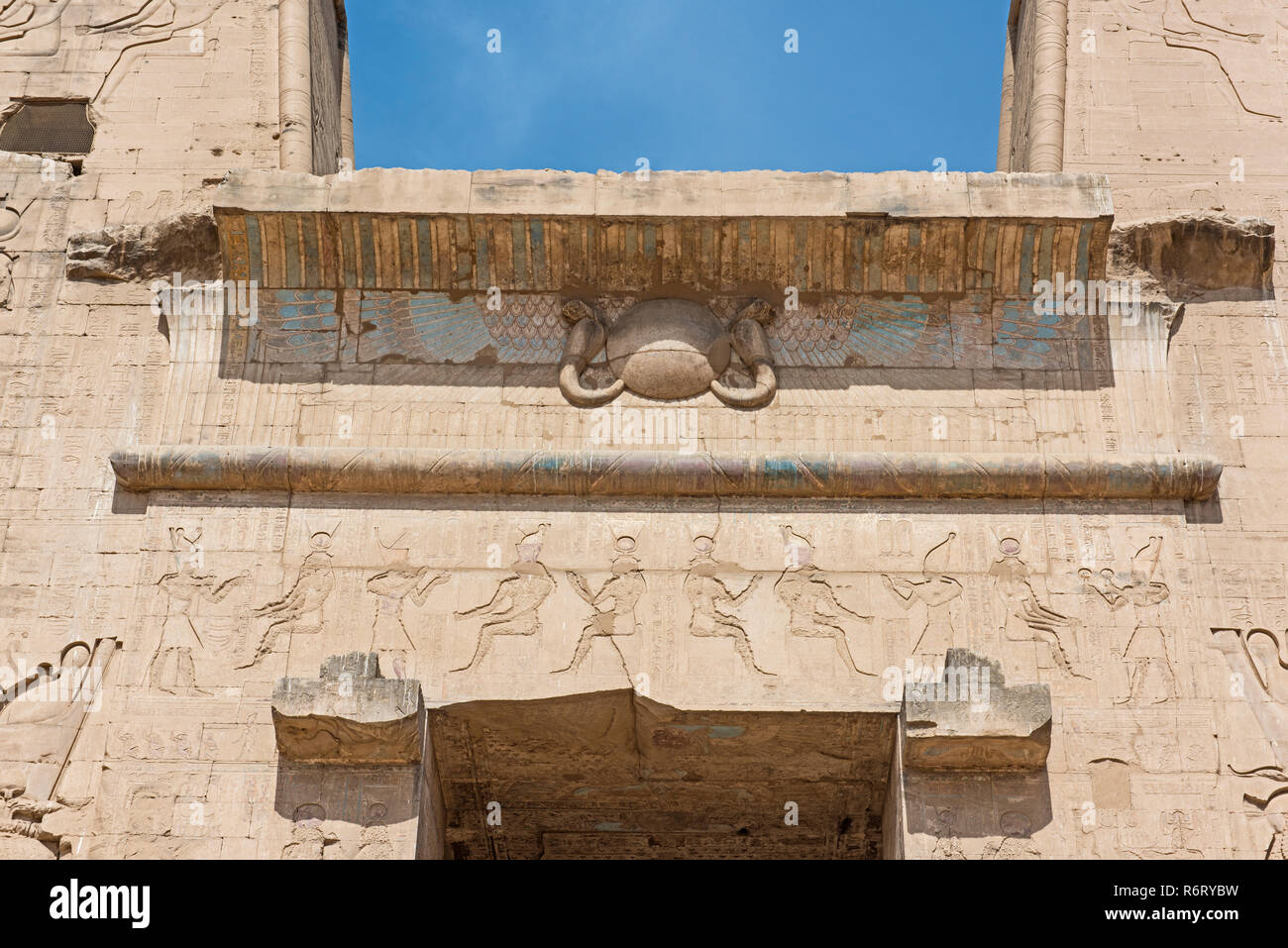 Hieroglypic Schnitzereien an der Wand am Eingang zum alten ägyptischen Tempel des Horus von Edfu Stockfoto