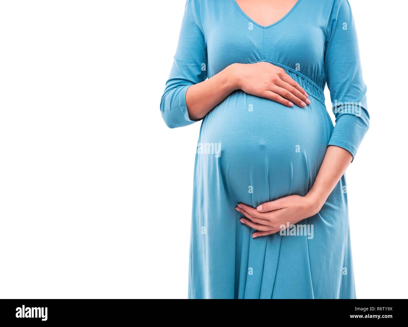 Schwangere Frau, die Hände auf dem Bauch. Close-up. Stockfoto