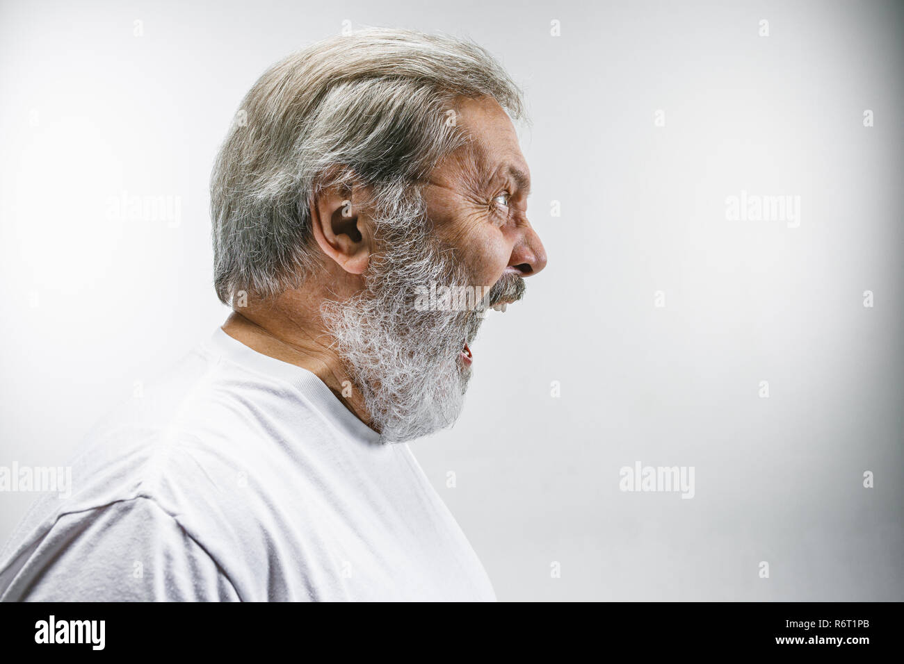 Die älteren emotionalen wütenden Mann schreiend auf weißem Studiohintergrund Stockfoto