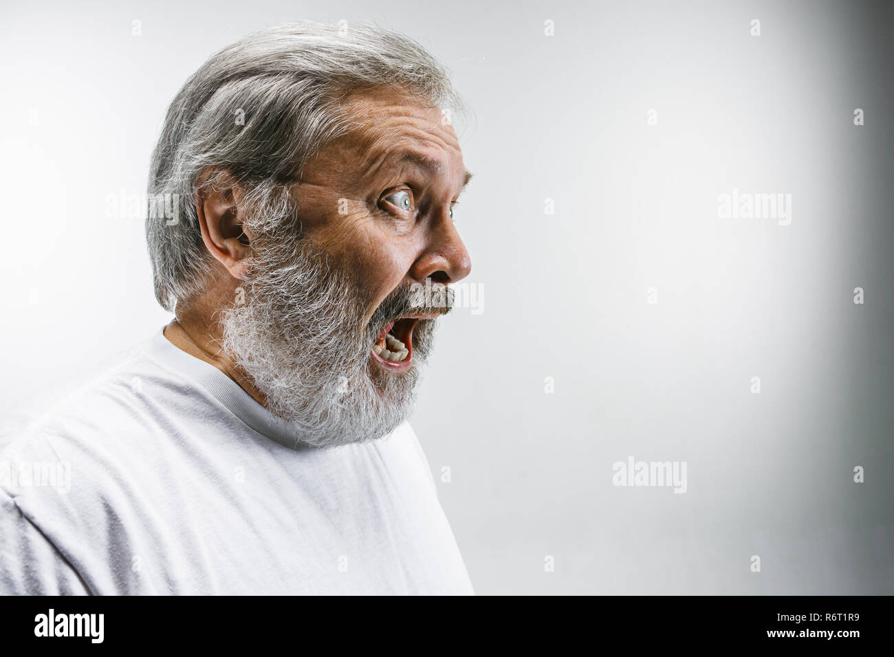 Die älteren emotionalen wütenden Mann schreiend auf weißem Studiohintergrund Stockfoto