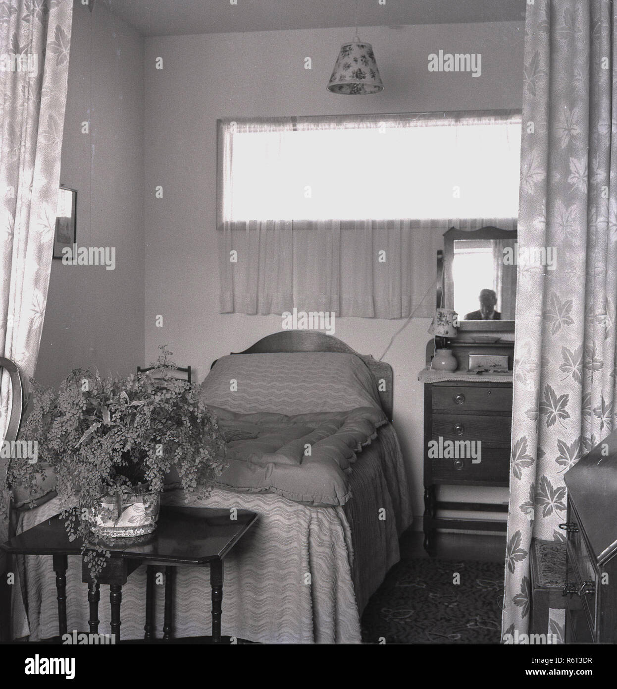 1960, historische, eine alte Perons' Bett und die umliegenden Möbeln in einem Pflege- oder Pflegeheim der Ära. Stockfoto