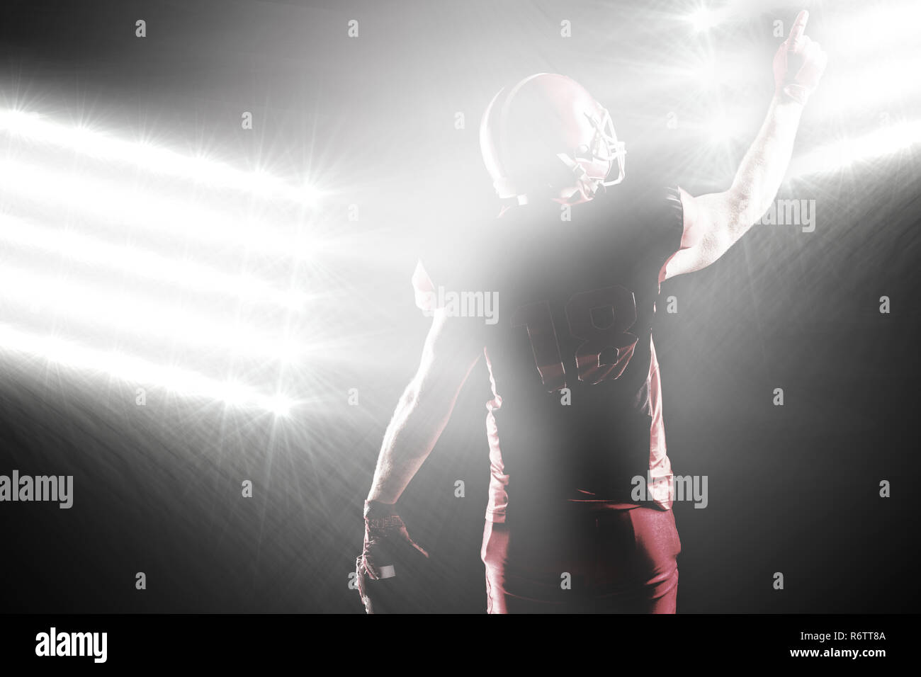 Spotlight gegen American football player im Helm nach oben Stockfoto