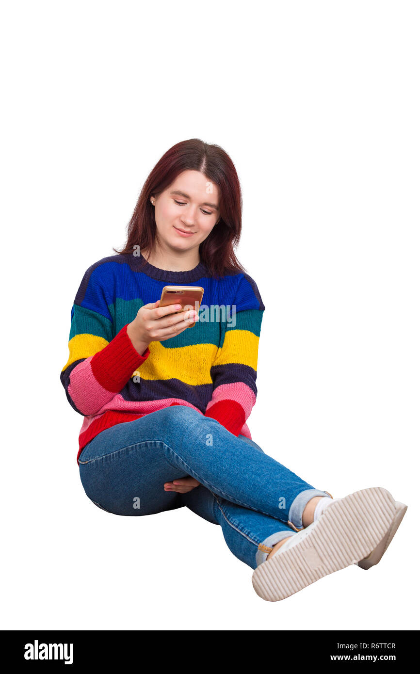 Entspannt junge Frau auf dem Boden sitzend Ihr Mobiltelefon über weißem Hintergrund surfen. Stockfoto