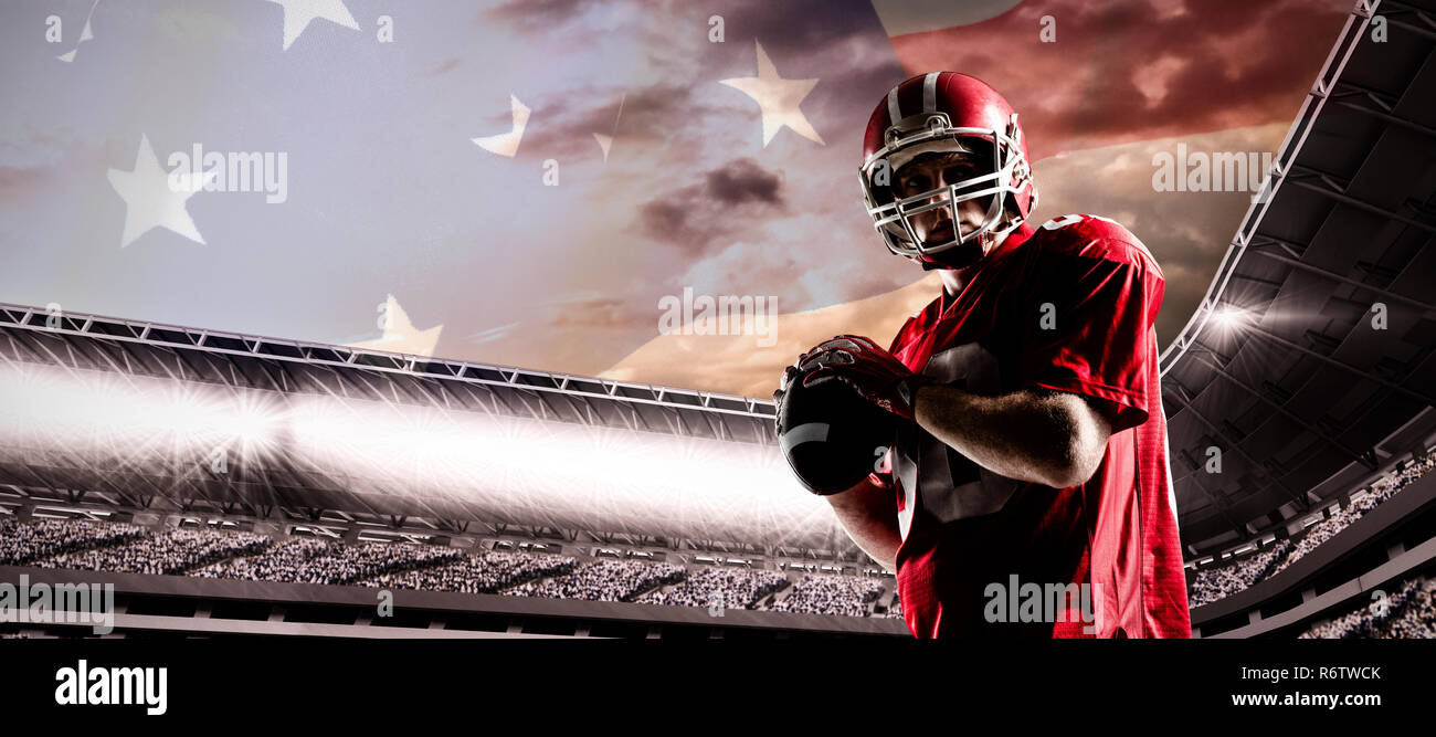 American Football Spieler mit Helm Vorbereitung Kugel gegen full frame Geschossen der nationalen Flagge zu werfen Stockfoto