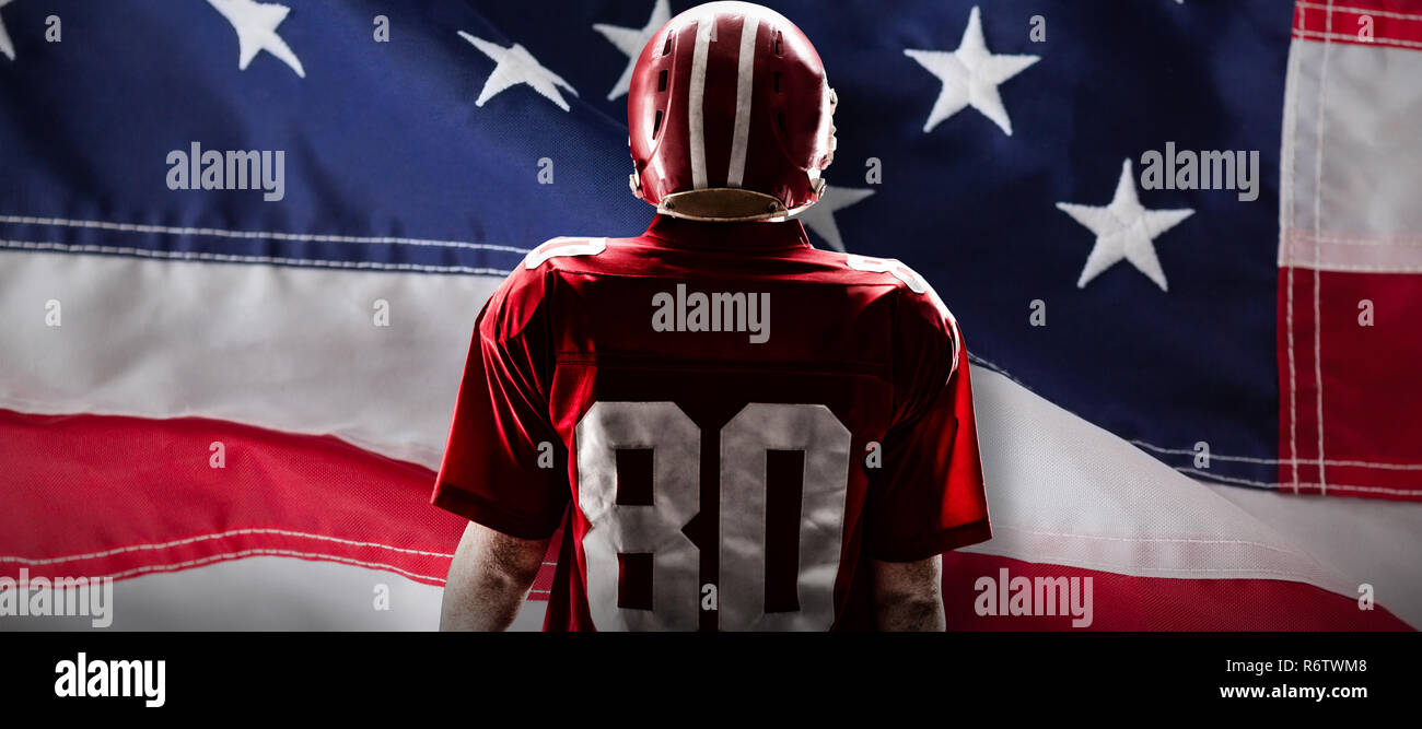 American football player im Helm gegen Nahaufnahme einer amerikanischen Flagge Stockfoto