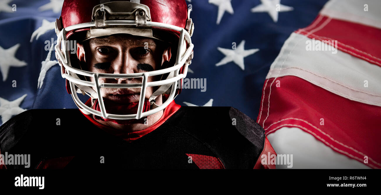 American football player im Helm gegen Full Frame der amerikanischen Flagge Stockfoto