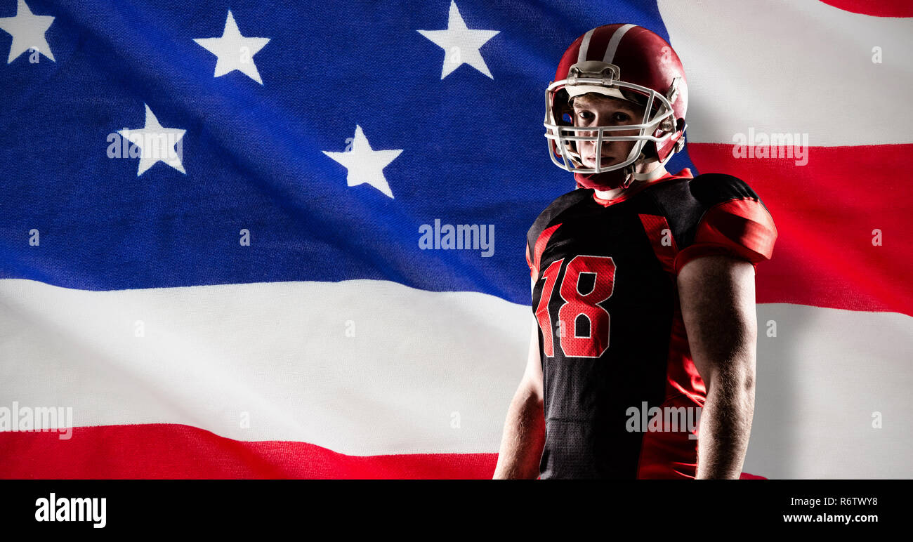 American football player stehend mit Rugby Helm gegen Nahaufnahme einer amerikanischen Flagge Stockfoto