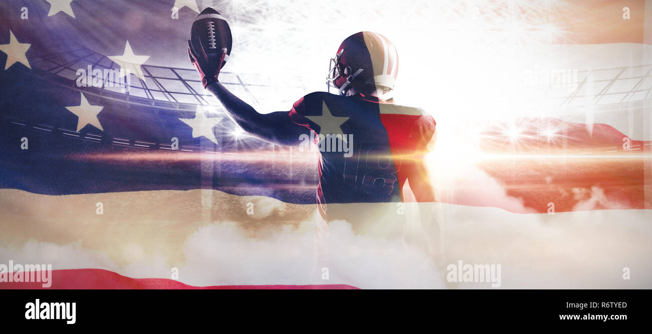 American football player im Helm Holding rugby ball gegen Nahaufnahme einer amerikanischen Flagge Stockfoto