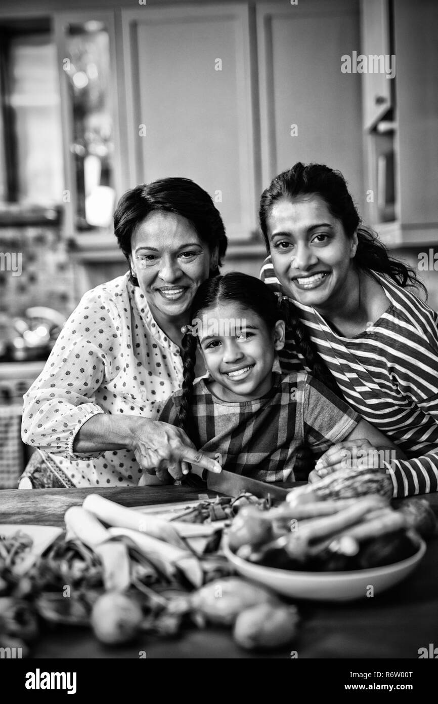 Portrait der lächelnden Multi-Generation-Familie, die in der Küche Essen zubereitet Stockfoto