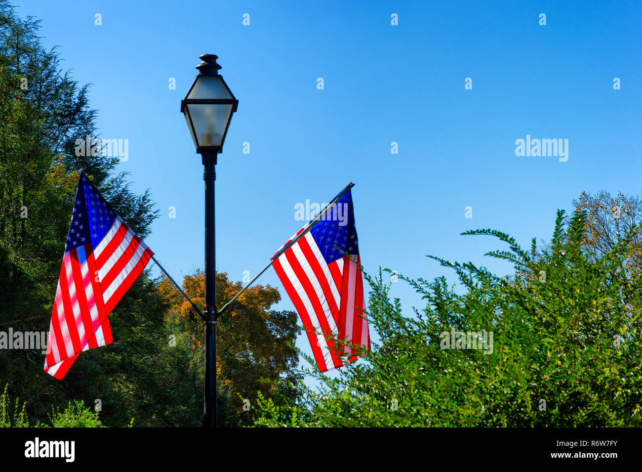 Street Lamp Post mit zwei USA Fahnen befestigt Stockfoto