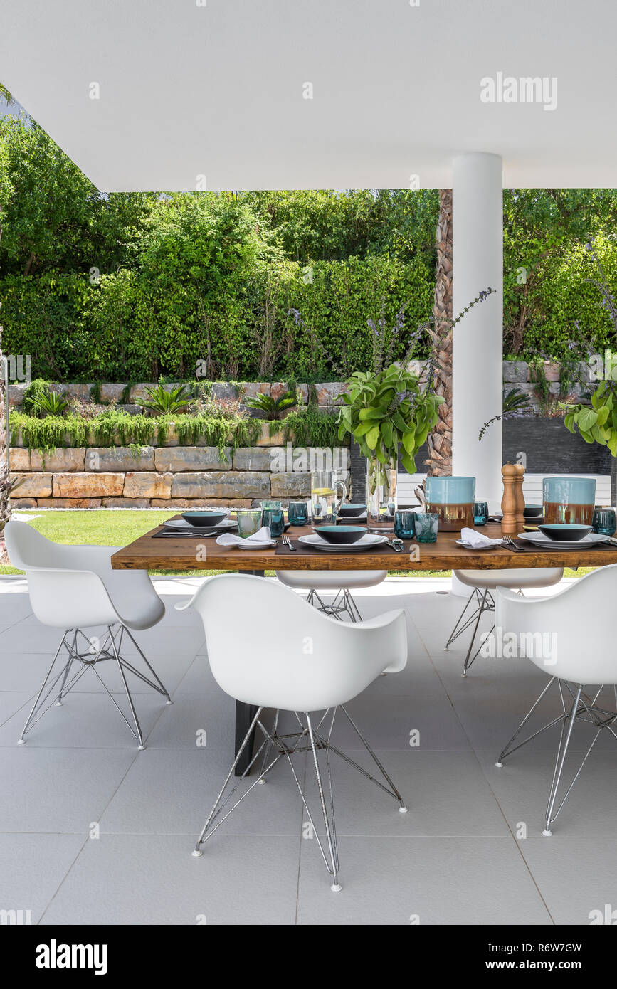 Esstisch aus Holz und DSW Typ Stühle für das Mittagessen auf der Terrasse des Neuen sahded Villa bauen, Quinta do Lago eingestellt Stockfoto