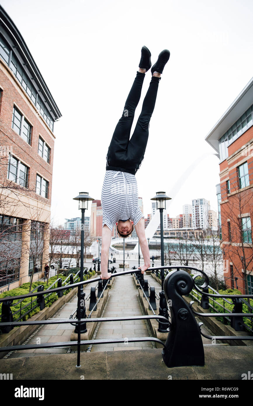 Freerunner macht Handstand in der Stadt Stockfoto